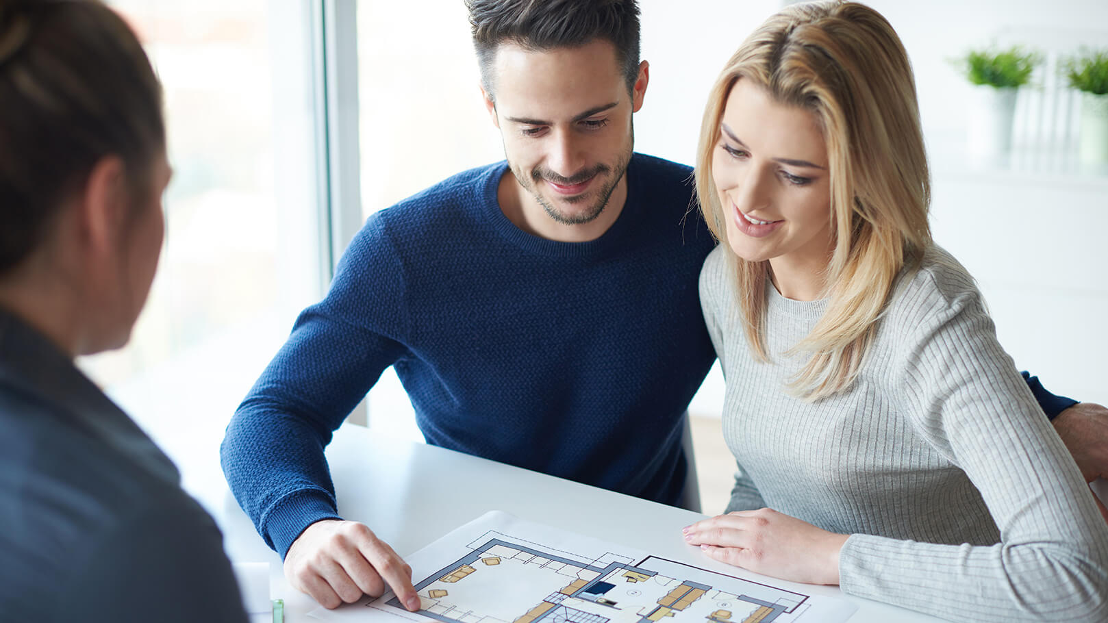 Young couple look over a diagram received from a house survey Young couple look over a diagram received from a house survey